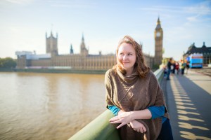 Young tourist in London on Westminster bridge having fun on a fall or spring day